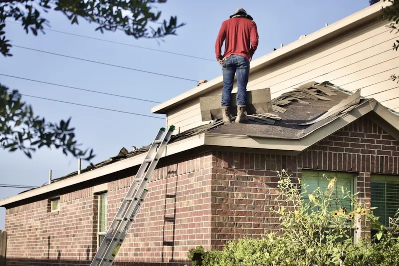 Professional roofer working on a residential roof in Ava